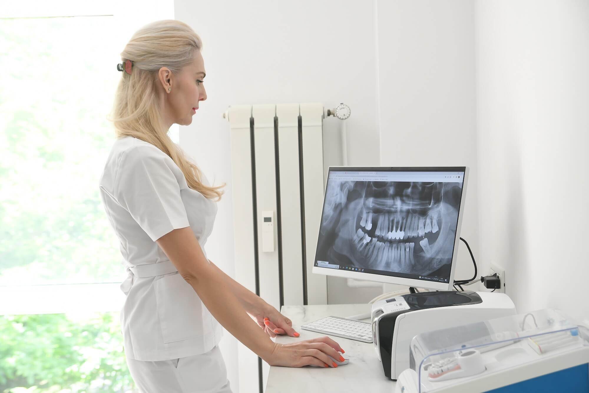 Dr. Andreea Panaite analizează radiografie dentară pentru diagnosticarea și planificarea tratamentului parodontozei